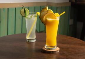 une verre de pastèque jus secouer avec épicé limonade, brut pastèque, paille isolé sur en bois table côté vue en bonne santé boisson pour vitamine c photo