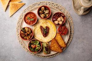 Espagnol petit déjeuner avec pain, haricots, salade et poisson servi dans plat isolé sur table Haut vue de arabe petit déjeuner photo