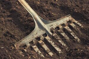 ai généré jardinage conséquences utilisé sale métal cultivateur proche en haut sur sol photo