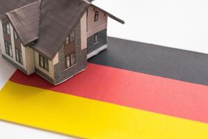petit maison sur une drapeau - vivant ou migrer à Allemagne photo