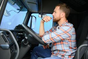 Masculin un camion chauffeur parlant par cb radio système dans le sien véhicule photo