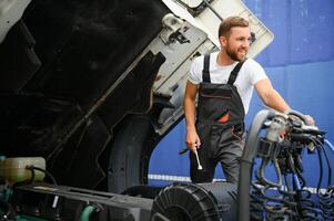 professionnel un camion mécanicien travail dans véhicule réparation service. photo