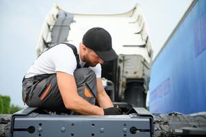 mécanicien réparer le un camion dans service. photo