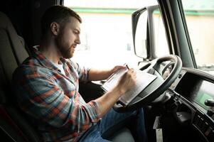 côté vue de professionnel chauffeur derrière le roue dans camion cabine. photo