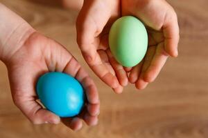 peindre des œufs pour Pâques, brillant Pâques vacances, les enfants peindre œufs, coloré des œufs dans une panier, coloré des œufs sur une rester, vacances Contexte photo