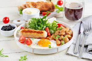 Anglais petit déjeuner. céto petit déjeuner. frit œuf, haricots, poulet saucisse et café Coupe. photo