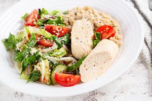 petit déjeuner flocons d'avoine bouillie avec bouilli fait maison poulet saucisse et Frais salade. en bonne santé équilibré aliments. branché aliments. photo