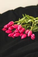 une bouquet de rose fleurs cousu sur noir élégant lin. photo