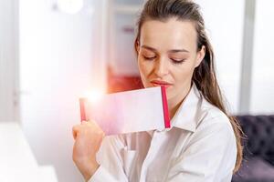 fille avec brochure à le réception. client dans spa. femme s beauté concept. photo