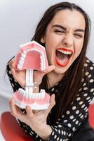 modèle de artificiel mâchoire avec les dents dans mains. dentiste cabinet Contexte. dentisterie concept. photo