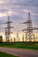 électricité pylônes palier le Puissance la fourniture à travers une rural paysage pendant le coucher du soleil. sélectif se concentrer. photo