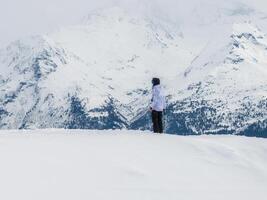 une seul figure admire le neigeux pics dans verbier, la suisse paysage photo