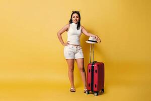 Jeune voyageur femme touristique en attendant. voyageur avec valise Regardez à caméra. photo