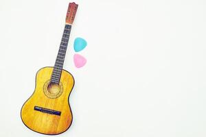 Jaune acoustique guitare, médiateur plectre sur blanc photo