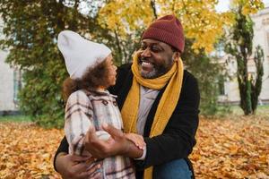 grand-père et petite-fille noirs s'amusant en jouant ensemble dans un parc d'automne