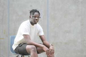 une Jeune homme avec le sien coiffure et le atmosphère de vivant dans le communauté. photo