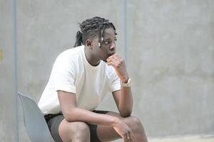 une Jeune homme avec le sien coiffure et le atmosphère de vivant dans le communauté. photo