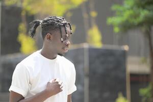 une Jeune homme avec le sien coiffure et le atmosphère de vivant dans le communauté. photo