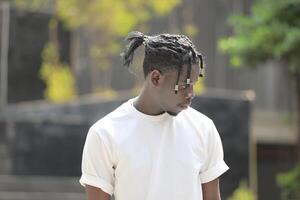 une Jeune homme avec le sien coiffure et le atmosphère de vivant dans le communauté. photo