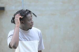 une Jeune homme avec le sien coiffure et le atmosphère de vivant dans le communauté. photo