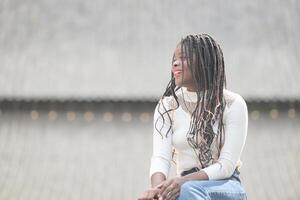 une Jeune femme avec le sien coiffure et le atmosphère de vivant dans le communauté. photo