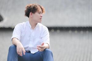 une Jeune homme avec le sien coiffure et le atmosphère de vivant dans le communauté. photo