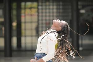 une Jeune femme avec le sien coiffure et le atmosphère de vivant dans le communauté. photo