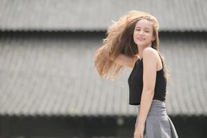 une Jeune femme avec le sien coiffure et le atmosphère de vivant dans le communauté. photo