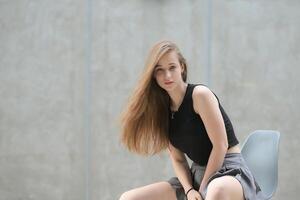 une Jeune femme avec le sien coiffure et le atmosphère de vivant dans le communauté. photo