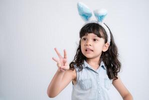 content peu fille avec Pâques œufs, lapin, et une gros sourire, rayonnant joie et innocence photo