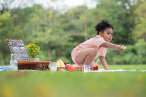 content famille profiter une pique-nique dans le parc, avec enfant en mangeant confiture pain, entouré par la nature photo