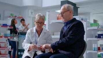 personnes âgées pharmacien coupure Sénior patient doigt en utilisant impulsion oxymètre, surveillance niveau de du sang oxygène saturation et cœur taux pendant annuel examen dans pharmacie offre plein intervalle de prestations de service photo