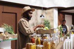 un africain américain gars cueillette Frais des fruits et légumes et admire BIO, durable des produits. le marché favorise local Les agriculteurs par fournir salubre nourriture avec une réduit carbone empreinte. photo