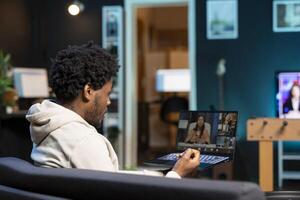 éloigné ouvrier pourparlers avec planche de réalisateurs pendant appel vidéo affaires réunion de Accueil bureau. télétravailleur parle dans éloigné conférence vidéo télétravail appel, recevoir retour d'information de la gestion photo