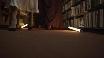 femmes sont mystérieusement en marchant dans bibliothèque. Stock images. secret sororité dans nuit bibliothèque. élégant femmes mystérieusement recueillir dans nuit bibliothèque avec clignotant lumière photo