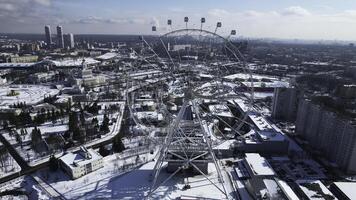 Haut vue de gros ferris roue dans l'hiver. créatif. magnifique Urbain paysage avec ferris roue dans ville centre dans l'hiver. ferris roue dans centre de gros ville sur ensoleillé hiver journée photo