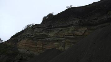 Terre carrière mur. agrafe. Naturel mur avec lignes de Terre rochers. mur de Terre après creusement sur nuageux pluvieux journée photo
