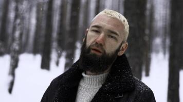 portrait de malheureux sans abri homme avec rouge nez sur une hiver du froid journée. médias. solitaire homme dans hiver forêt à la recherche ivre. photo