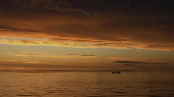 petit bateau sur Lac à le coucher du soleil. agrafe. Stupéfiant brillant Orange le coucher du soleil au dessus ondulation lac. photo