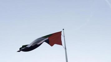 uni arabe émirats drapeau agitant dans le vent. action. drapeau contre bleu ciel. photo