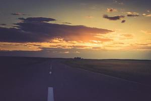 coucher de soleil ou une aube sur la route qui s'éloigne. photo