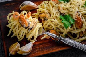 pâtes italiennes dans une sauce crémeuse aux fruits de mer, crevettes et moules sur une assiette photo