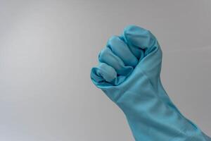 femelle main dans turquoise caoutchouc gants fabrication une poing geste sur blanc Contexte photo