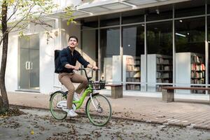 homme d'affaire et vélo dans ville à travail avec éco amical transport. content homme d'affaire professionnel équitation une vélo dans Urbain rue photo