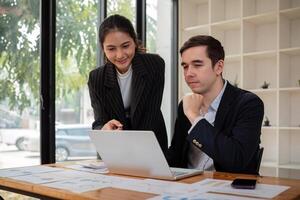 équipe affaires de diverse partenaire affaires femme discuter projet sur portable séance à table dans bureau. deux collègue de professionnel affaires gens travail ensemble photo