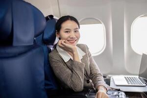 une femme d'affaires est séance sur avion siège avec une sourire sur sa visage photo