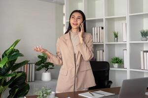 travail de maison. femme d'affaires en utilisant portable ordinateur et téléphone intelligent dans sa chambre. éco amical femme d'affaires travail sur bureau, free-lance photo