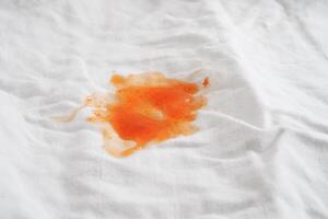 tache de sauce tomate sale ou ketchup sur un chiffon à laver avec de la lessive en poudre, concept de nettoyage des travaux ménagers. photo