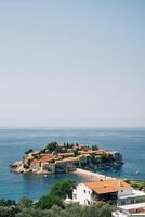 vue plus de le rouge toits de vieux Maisons à le île de sveti Stéphane. Monténégro photo