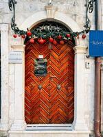 Kotor, Monténégro - 25 décembre 2022. enguirlandé en bois porte à un vieux bâtiment avec une signe à le entrée. légende. boutique hôtel, astoria photo